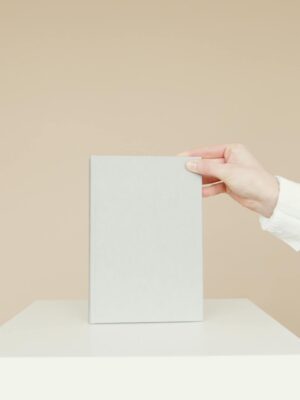 Simple minimalist image of a blank book being held by a person's hand, ideal for branding.